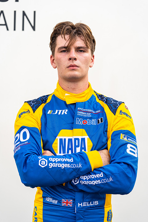 Hugo Ellis faces the camera with his arms crossed in NAPA Racing overalls
