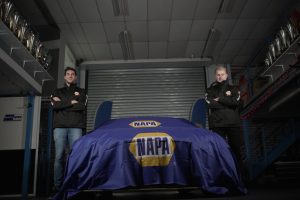 Dan Cammish and Ash Sutton next to NAPA Racing UK Car hidden by NAPA cover.