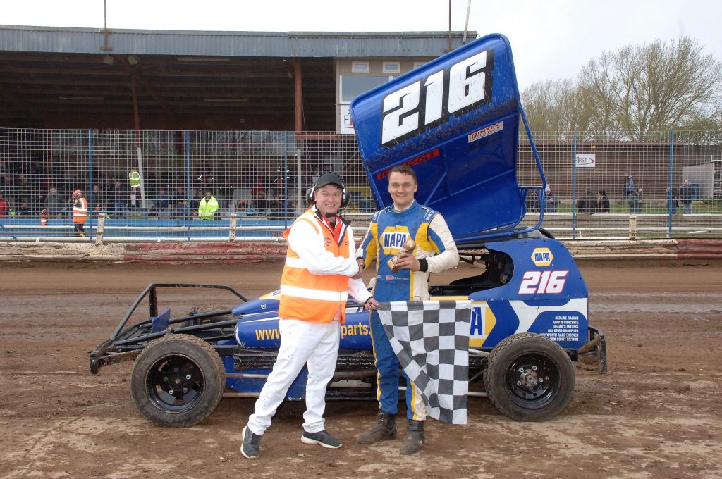 Jack France holds BriSCA trophy in front of his NAPA Stock Car