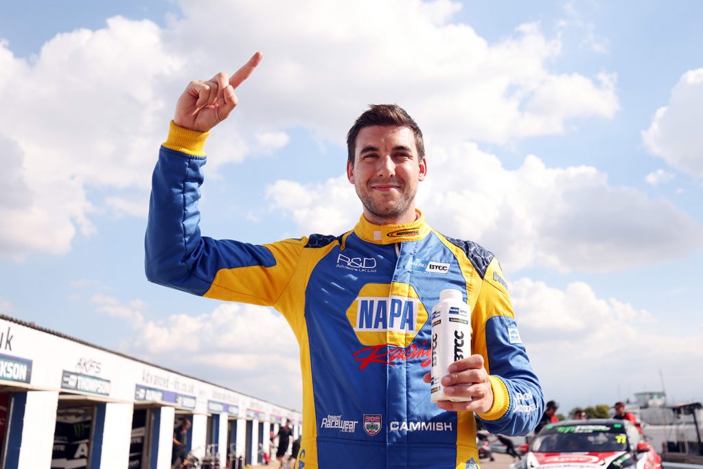 NAPA Racing UK's Dan Cammish grins at the camera and holds up a "one" with his finger, celebrating his win at BTCC Thruxton.