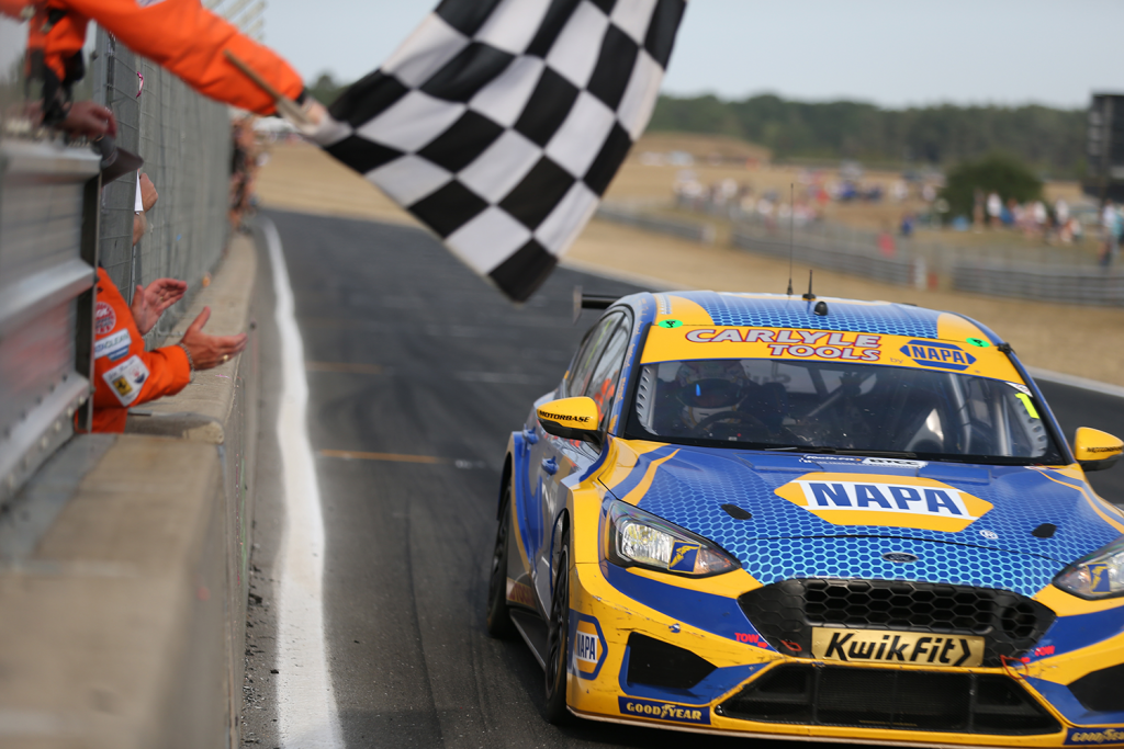 NAPA Racing UK's Ash Sutton speeds past the checkered flag as he claims first place.