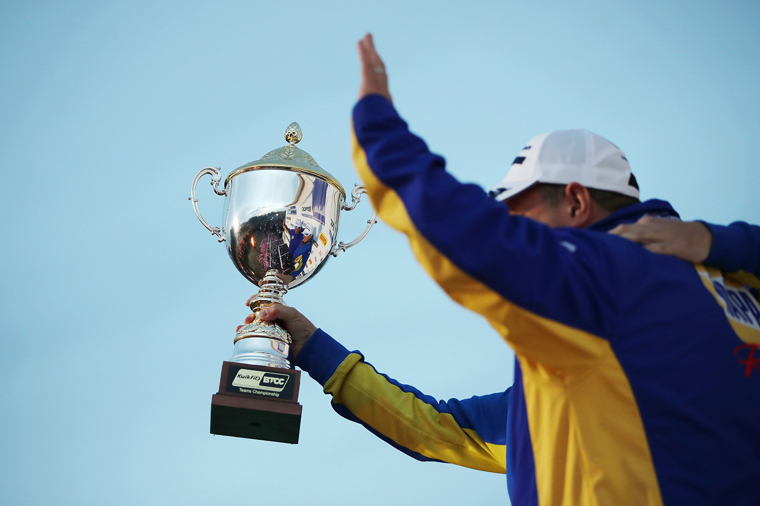 NAPA Racing UK teammates celebrate their BTCC Teams Championship win with the trophy raised in the air